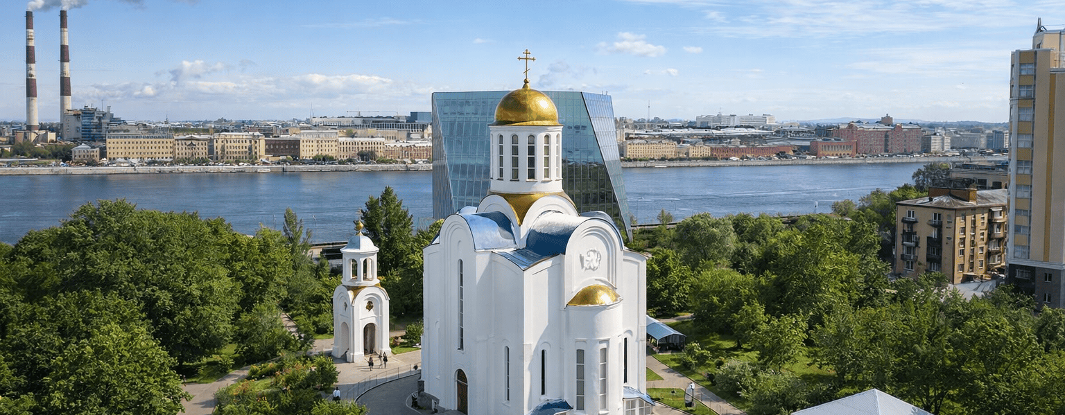 Вид на Блокадный храм Успения Пресвятой Богородицы с золотыми куполами и мемориальными памятниками